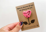 a hand holding a card with a pink flower on it